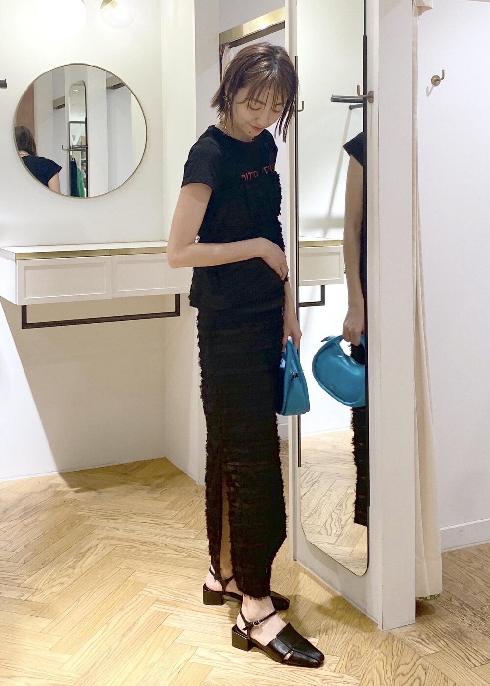 ブラック系のサンダル、ブラック系のスカート、ブラック系のキャミソールを着用したレディースの春コーディネートの3枚目の写真