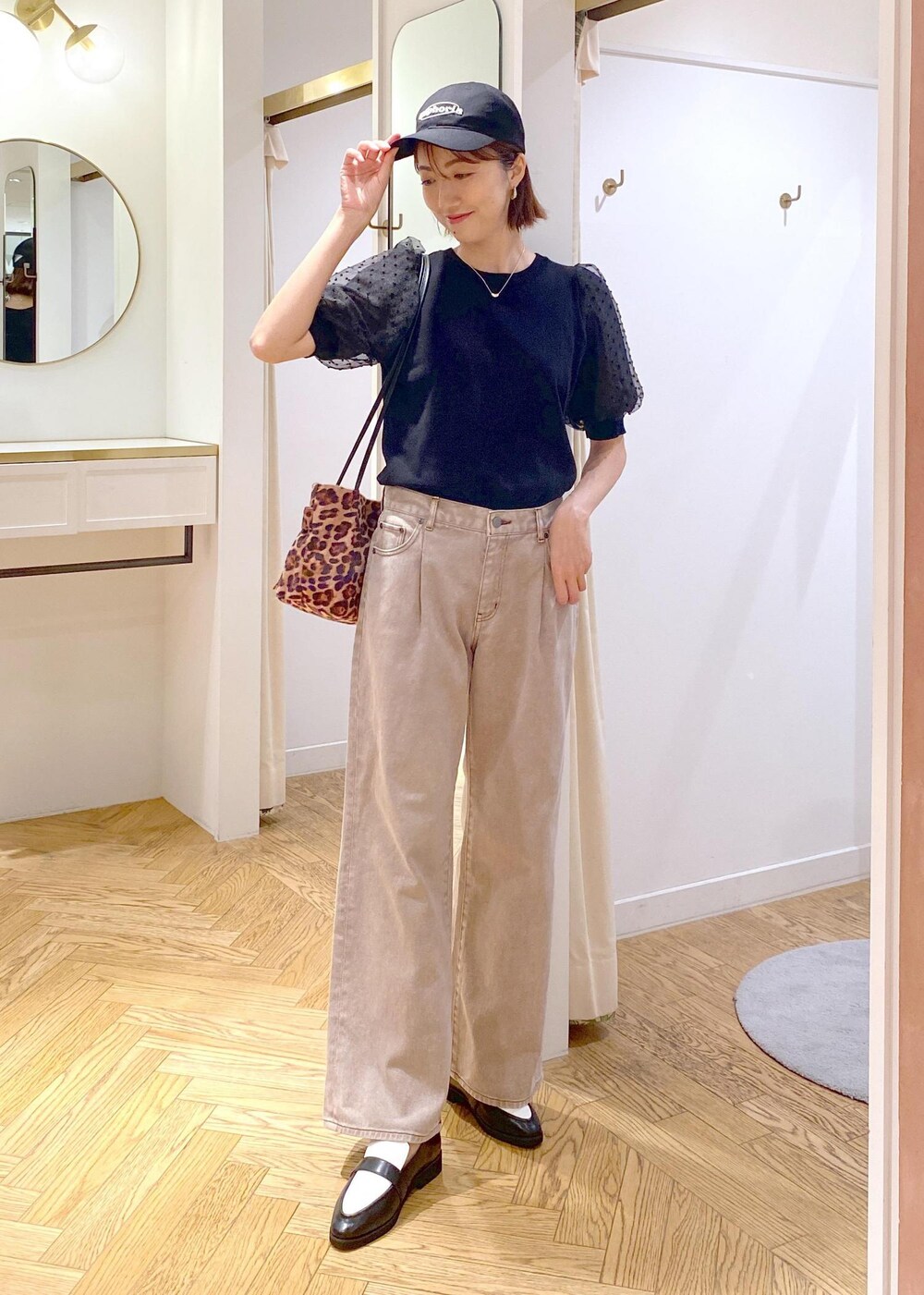 ブラック系のローファー、ブラック系のニット/セーター、ブラウン系のデニムパンツを着用したレディースの夏コーディネートの8枚目の写真