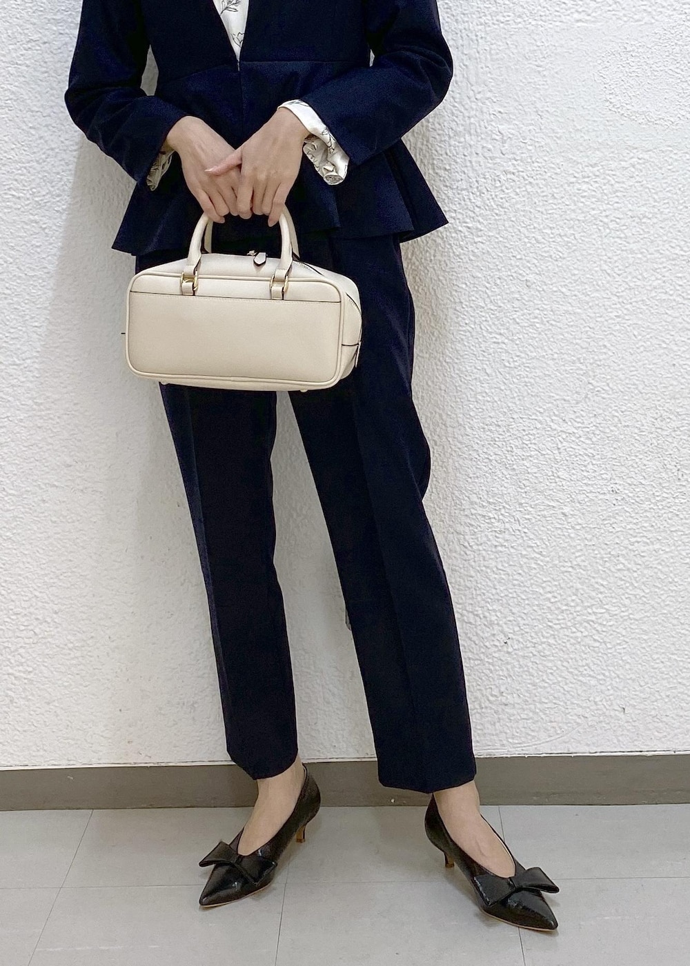 ブラック系のパンプス、ホワイト系のシャツ/ブラウス、ブルー系のスラックスを着用したレディースの冬コーディネートの3枚目の写真