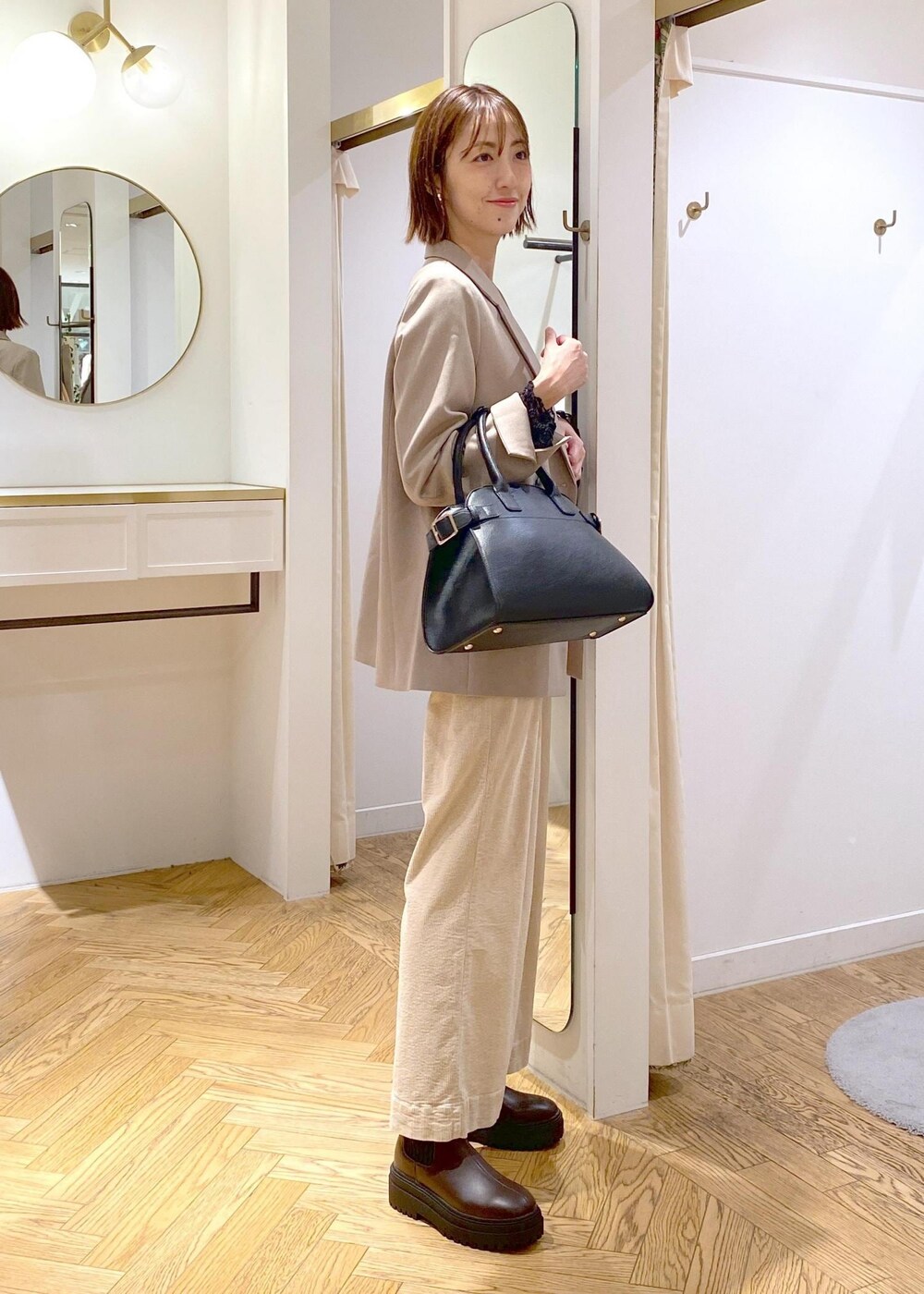 ブラック系のトートバッグ、ブラウン系のブーツ、ブラック系のTシャツ/カットソーを着用したレディースの秋コーディネートの6枚目の写真