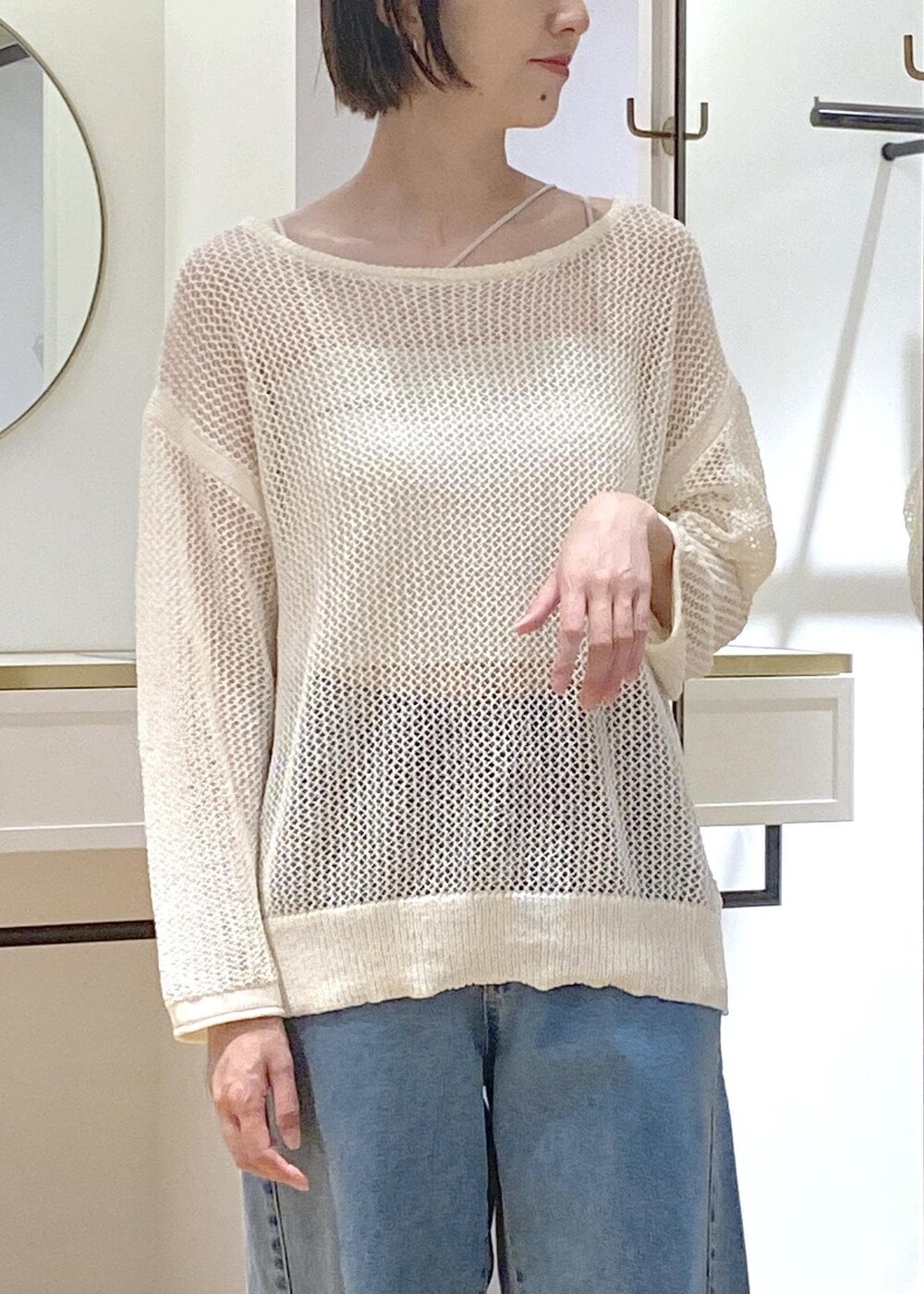 シルバー系のパンプス、シルバー系のトートバッグ、ブルー系のデニムパンツを着用したレディースの夏コーディネートの3枚目の写真