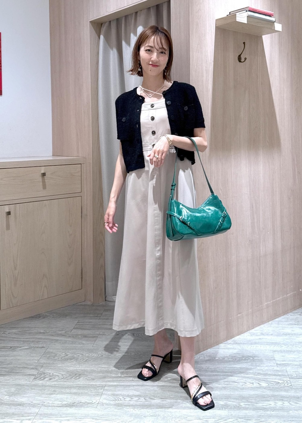 ホワイト系のキャミソール、ブラック系のサンダル、ブラック系のカーディガン/ボレロを着用したレディースの夏コーディネートの3枚目の写真