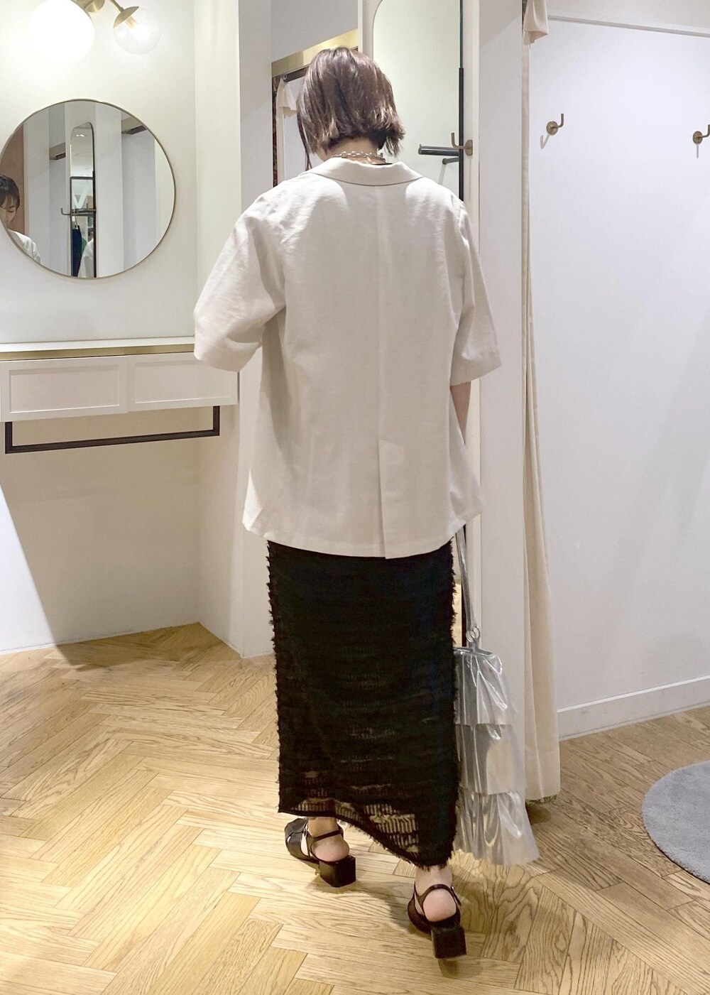 ブラック系のサンダル、ブラック系のTシャツ/カットソー、シルバー系のトートバッグを着用したレディースの夏コーディネートの3枚目の写真