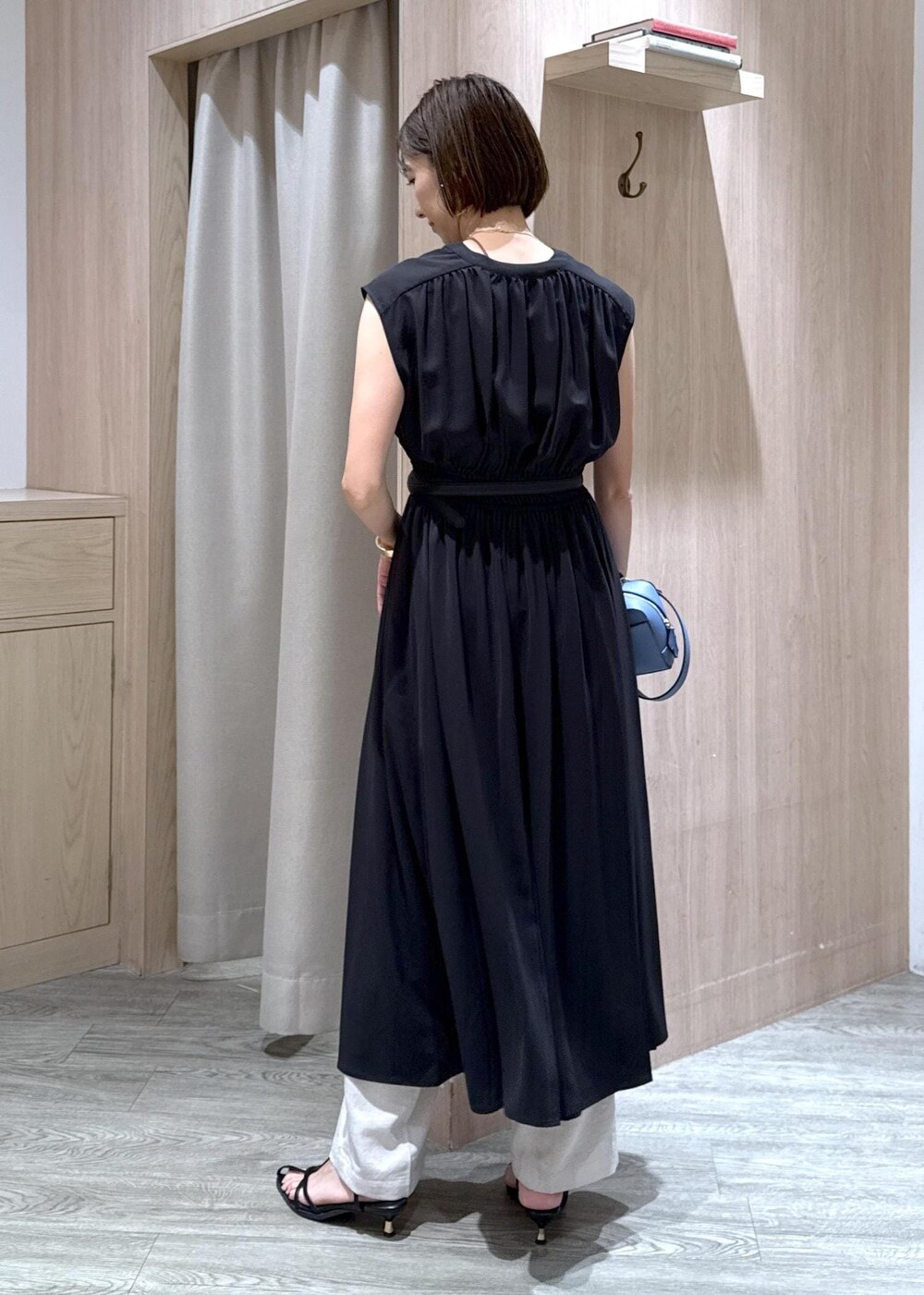 ブラック系のサンダル、ホワイト系のスラックス、ブラック系のワンピースを着用したレディースの夏コーディネートの3枚目の写真