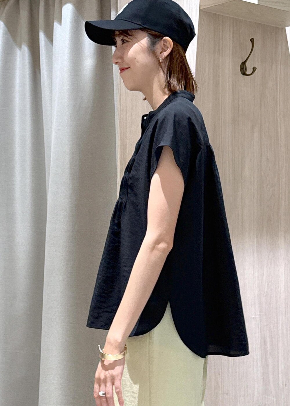 ブラック系のサンダル、イエロー系のスラックス、ブラック系のシャツ/ブラウスを着用したレディースの夏コーディネートの8枚目の写真