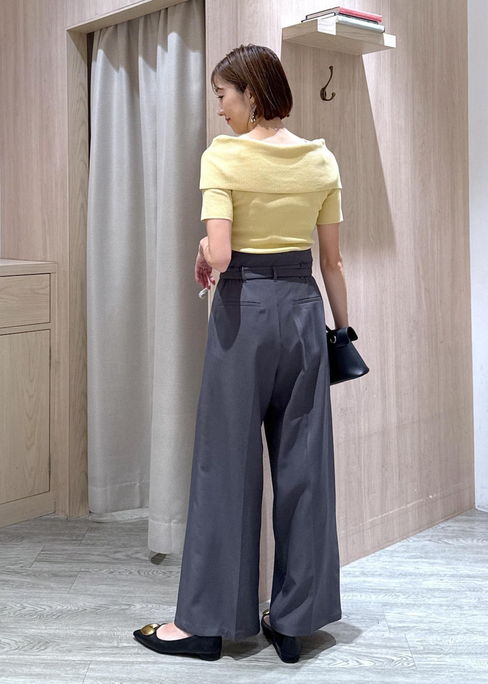 ブラック系のショルダーバッグ、ブラック系のバレエシューズ、イエロー系のニット/セーターを着用したレディースの夏コーディネートの2枚目の写真