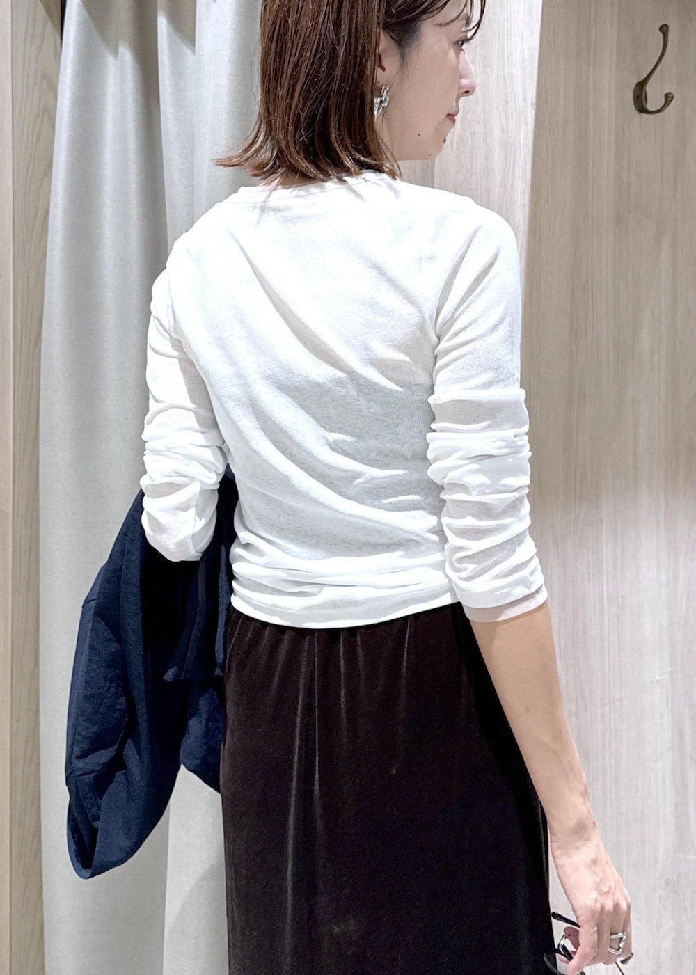 ブラック系のハンドバッグ、ブルー系のテーラードジャケット、ホワイト系のTシャツ/カットソーを着用したレディースの夏コーディネートの9枚目の写真