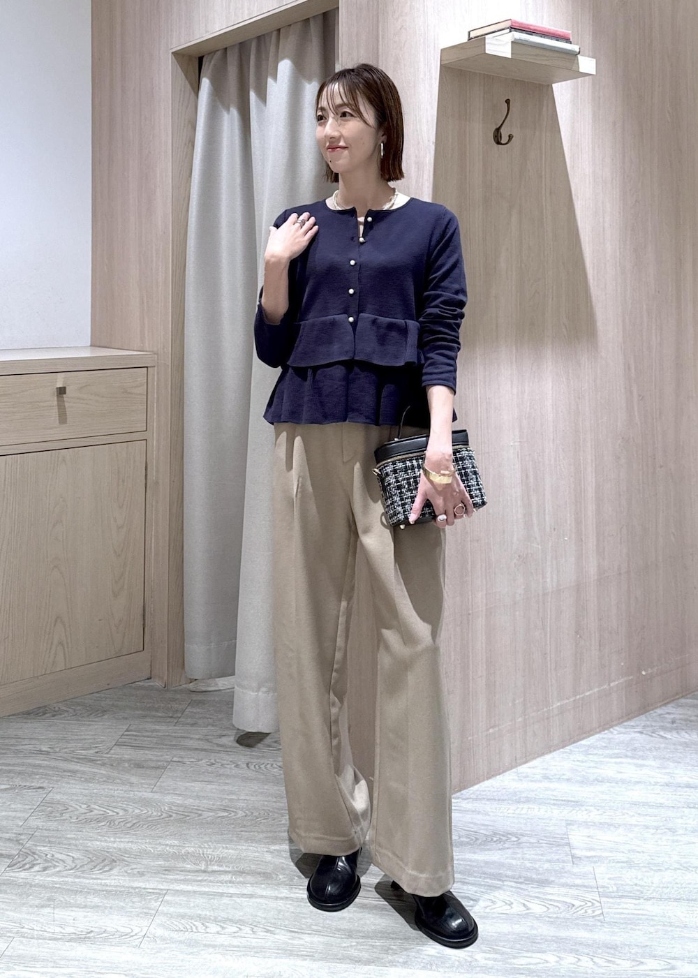 ベージュ系のスラックス、その他のハンドバッグ、ブルー系のカーディガン/ボレロを着用したレディースの冬コーディネートの4枚目の写真