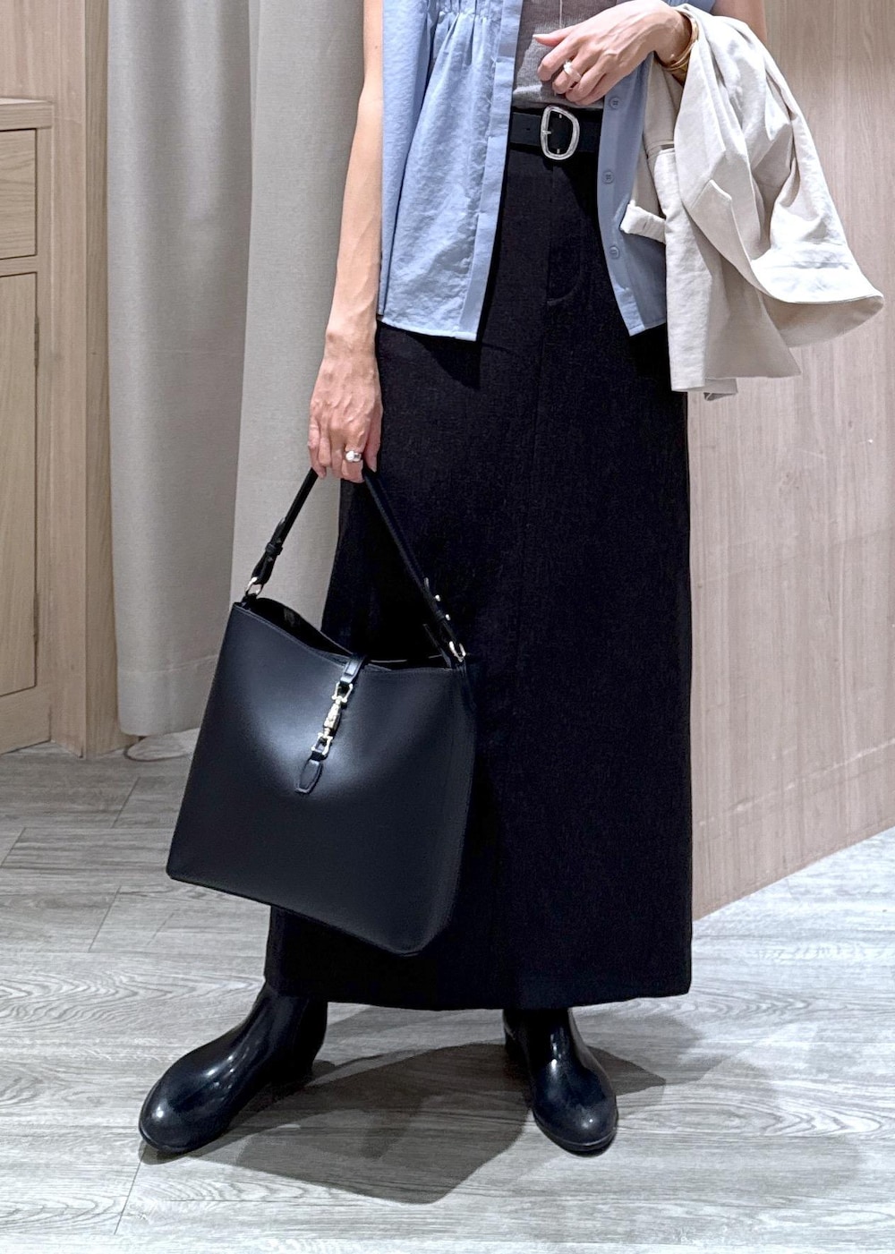 グレー系のタンクトップ、ホワイト系のテーラードジャケット、ブラック系のトートバッグを着用したレディースの夏コーディネートの6枚目の写真