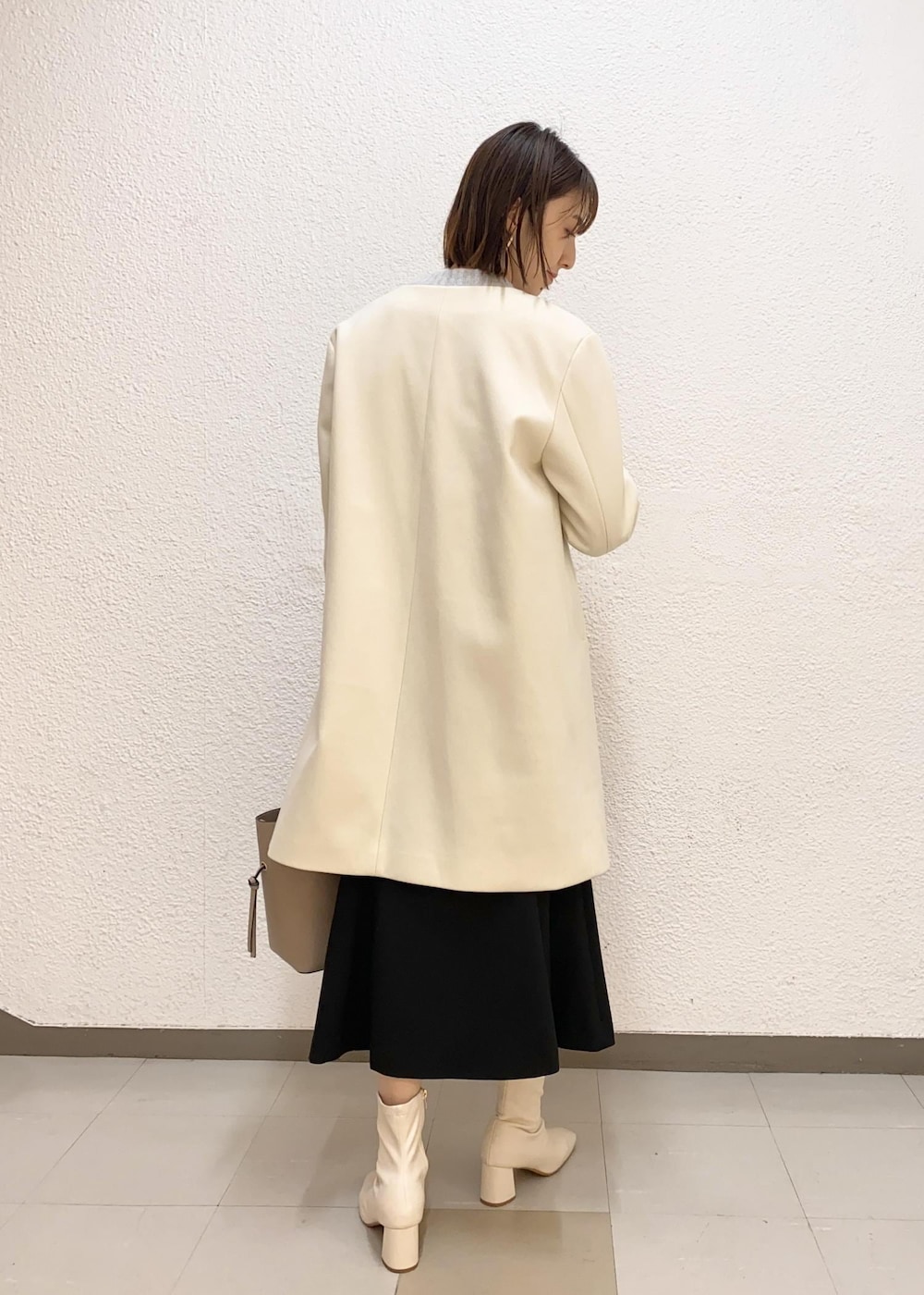 グレー系のカーディガン/ボレロ、ベージュ系のトートバッグ、ホワイト系のその他アウターを着用したレディースの冬コーディネートの3枚目の写真