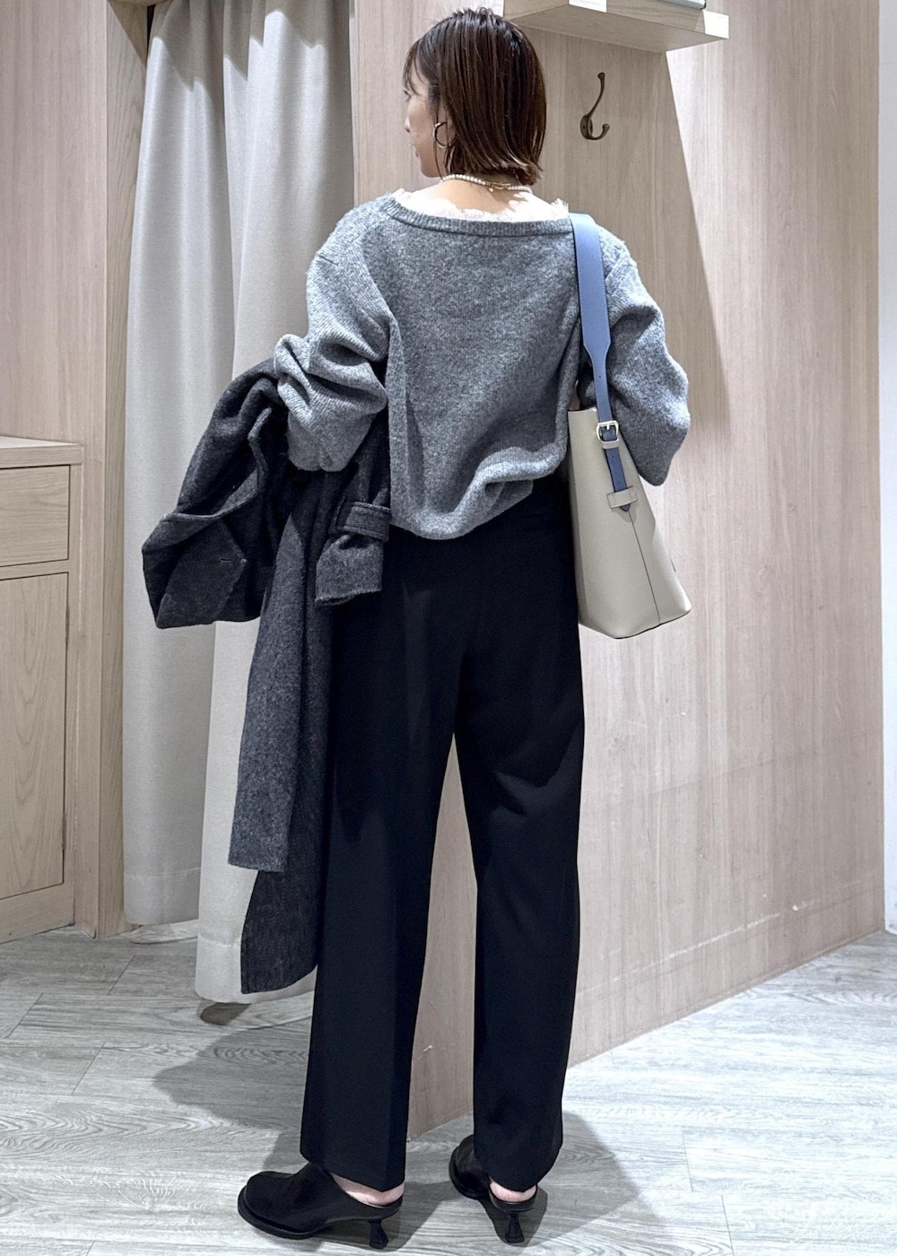 ベージュ系のトートバッグ、グレー系のその他アウター、ブラック系のその他パンツを着用したレディースの冬コーディネートの2枚目の写真