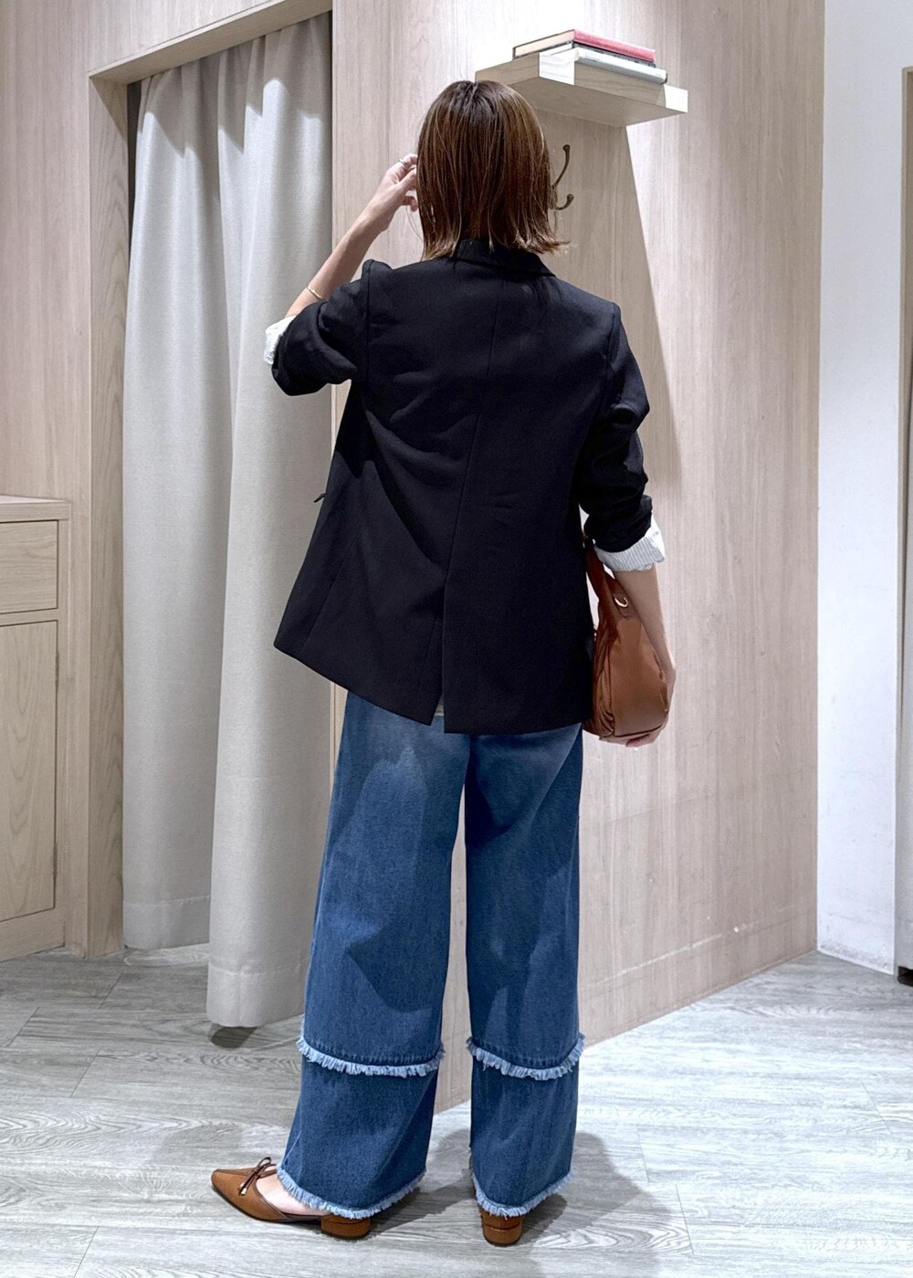 ブルー系のデニムパンツ、ブラック系のシャツ/ブラウス、イエロー系のパンプスを着用したレディースの秋コーディネートの3枚目の写真