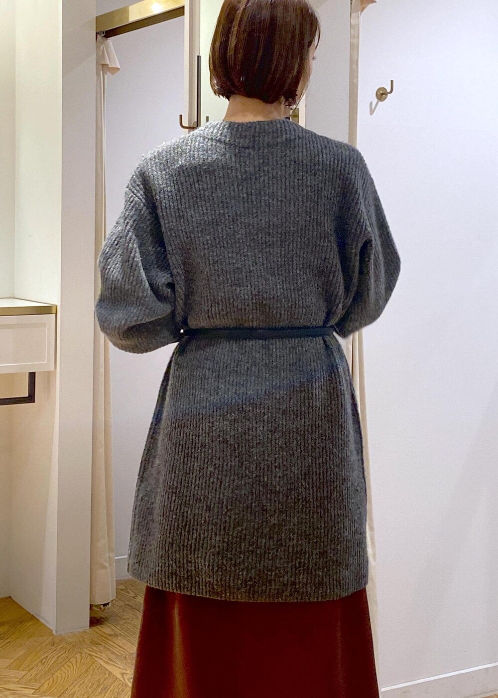 ホワイト系のブーツ、ブラウン系のスカート、グレー系のワンピースを着用したレディースの冬コーディネートの6枚目の写真