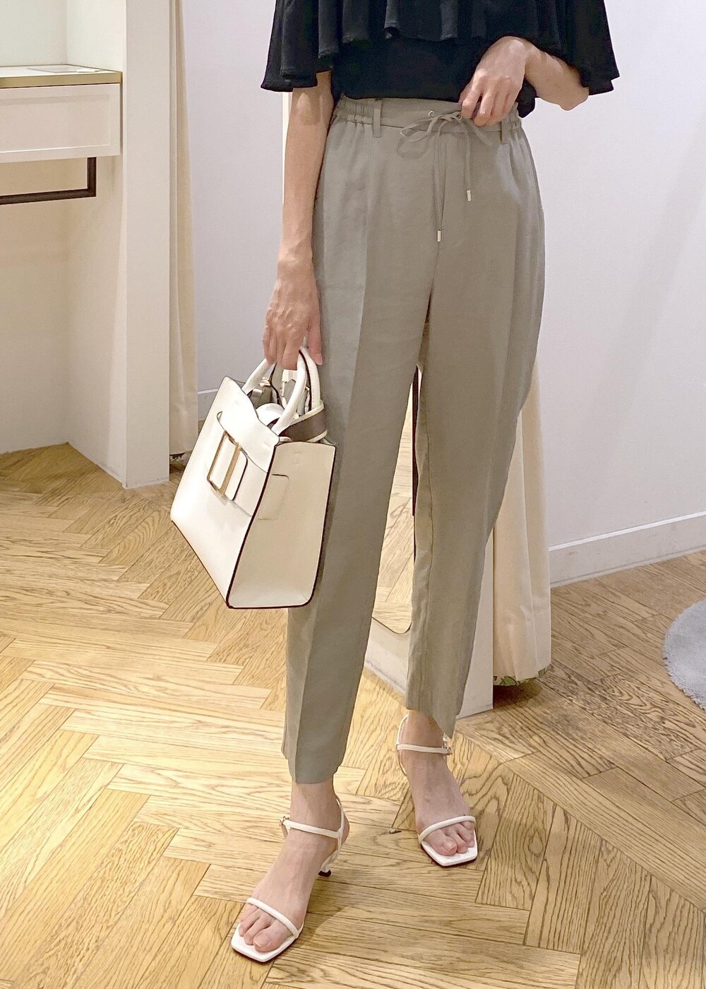 グリーン系のスラックス、ホワイト系のサンダル、ホワイト系のハンドバッグを着用したレディースの夏コーディネートの5枚目の写真