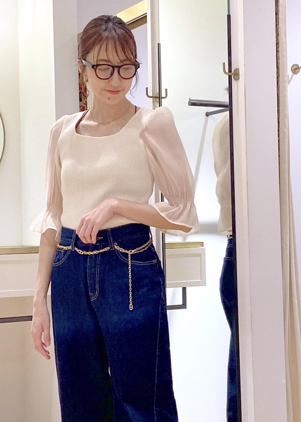 ホワイト系のローファー、ブラック系のショルダーバッグ、ブルー系のデニムパンツを着用したレディースの春コーディネートの3枚目の写真