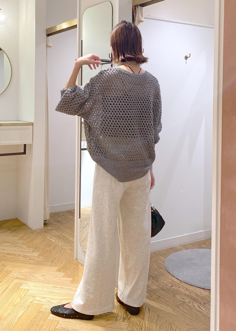 ホワイト系のその他パンツ、グレー系のニット/セーター、ブラック系のハンドバッグを着用したレディースの秋コーディネートの3枚目の写真