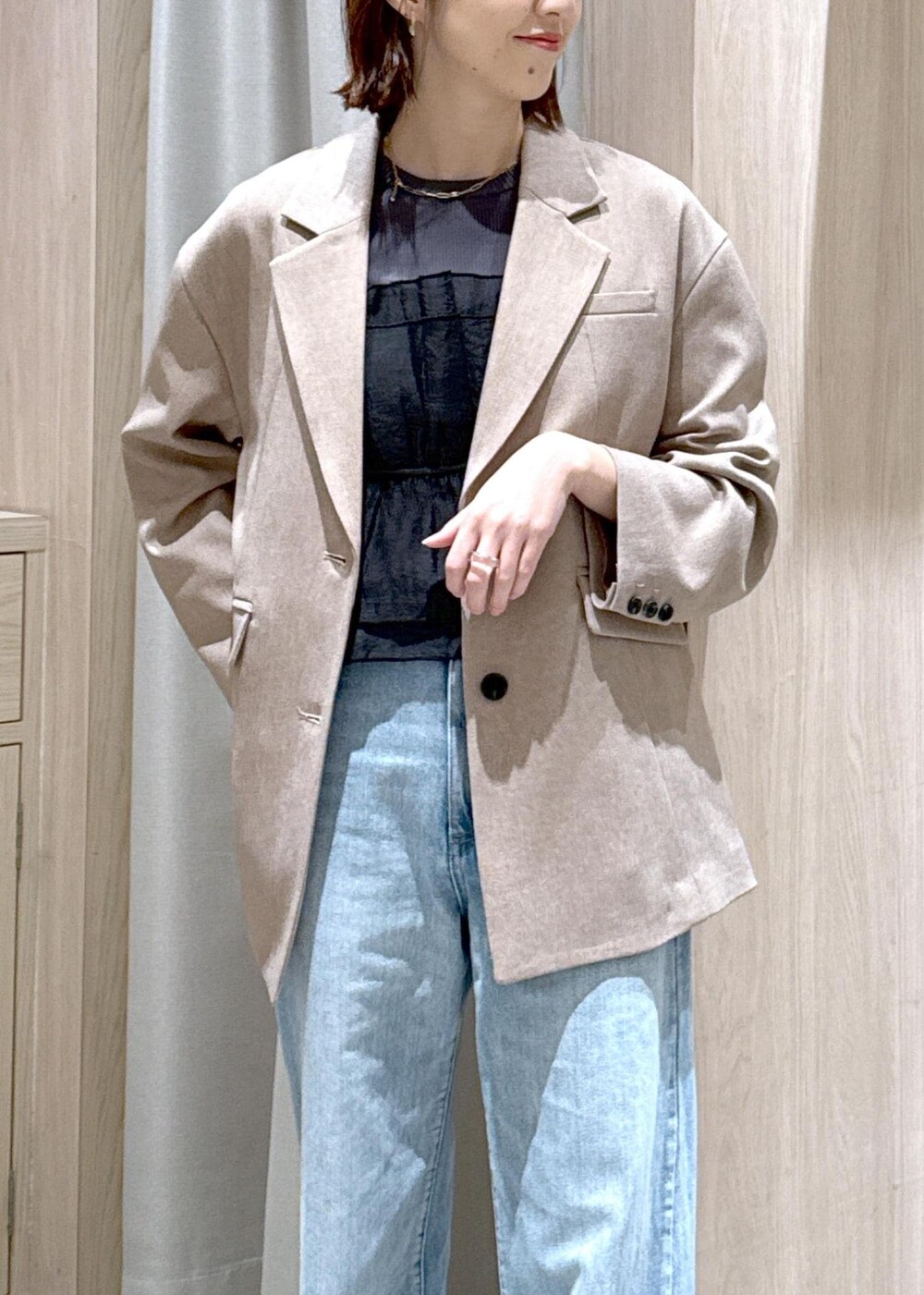 ブラック系のショルダーバッグ、ブルー系のデニムパンツ、イエロー系のテーラードジャケットを着用したレディースの春コーディネートの7枚目の写真