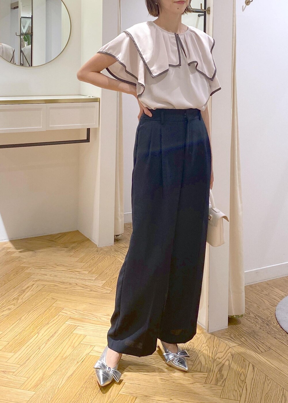 シルバー系のパンプス、ブラック系のキャミソール、ブルー系のスラックスを着用したレディースの夏コーディネートの4枚目の写真