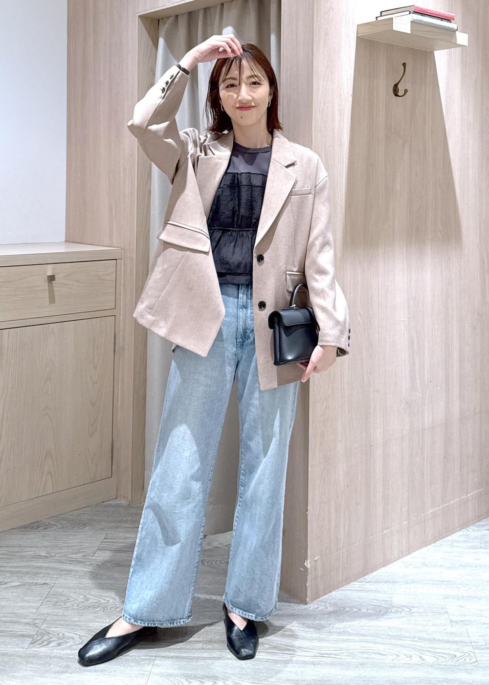 ブラック系のショルダーバッグ、ブルー系のデニムパンツ、イエロー系のテーラードジャケットを着用したレディースの春コーディネートの2枚目の写真