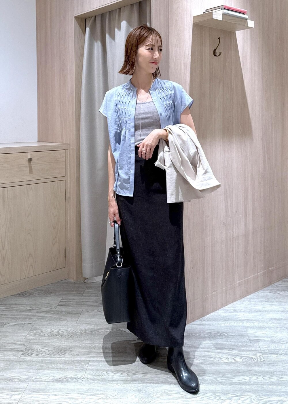 グレー系のタンクトップ、ホワイト系のテーラードジャケット、ブラック系のトートバッグを着用したレディースの夏コーディネートの2枚目の写真