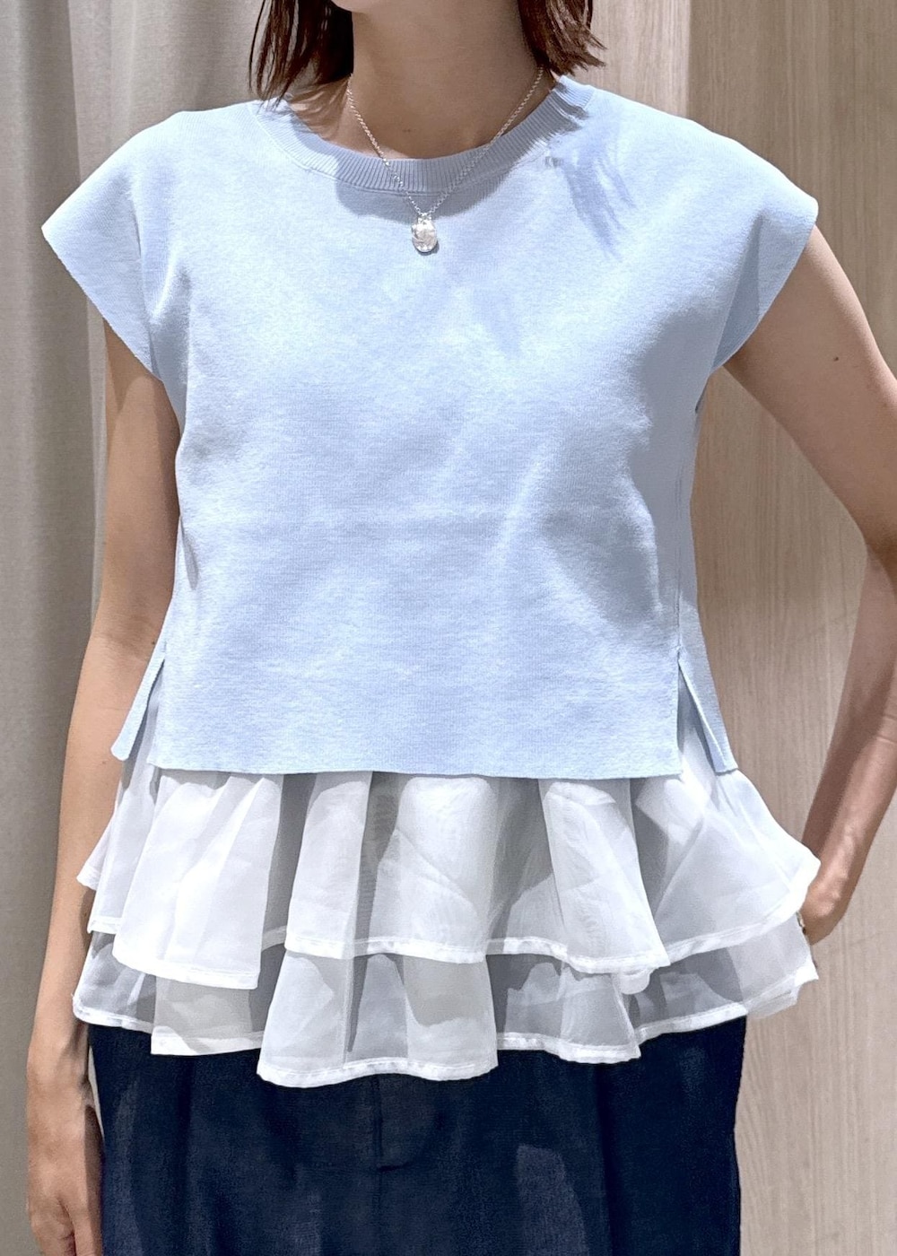 ブラック系のショルダーバッグ、ブラック系のパンプス、ブルー系のデニムパンツを着用したレディースの夏コーディネートの8枚目の写真