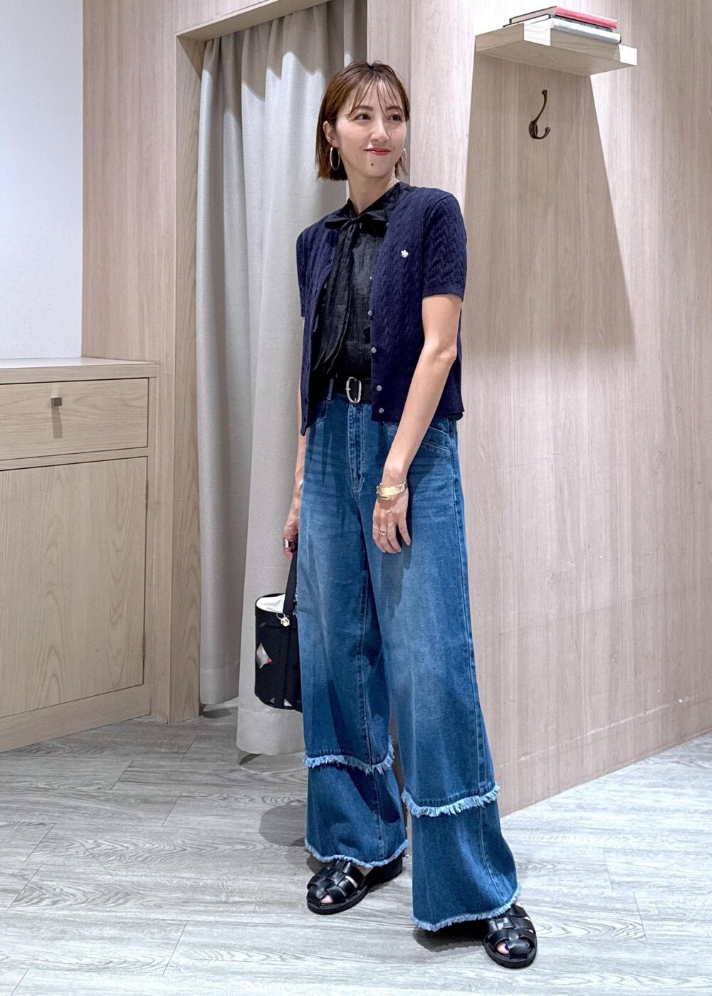 ブラック系のシャツ/ブラウス、ブルー系のカーディガン/ボレロ、ブラック系のハンドバッグを着用したレディースの夏コーディネートの2枚目の写真