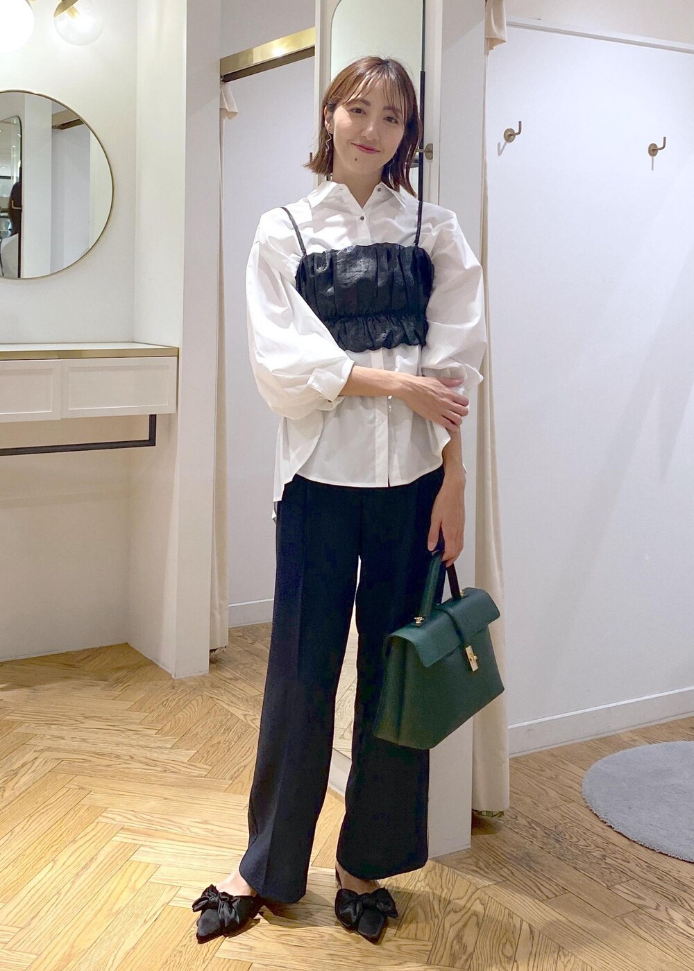 ブルー系のスラックス、ホワイト系のシャツ/ブラウス、グリーン系のハンドバッグを着用したレディースの秋コーディネートの4枚目の写真