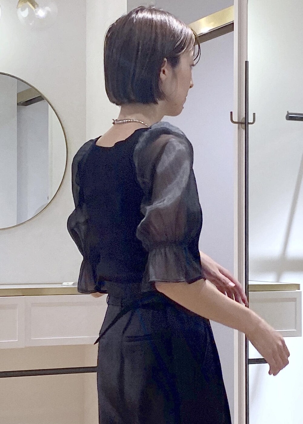 ブラック系のパンプス、ブラック系のショルダーバッグ、ブラック系のスラックスを着用したレディースの夏コーディネートの5枚目の写真