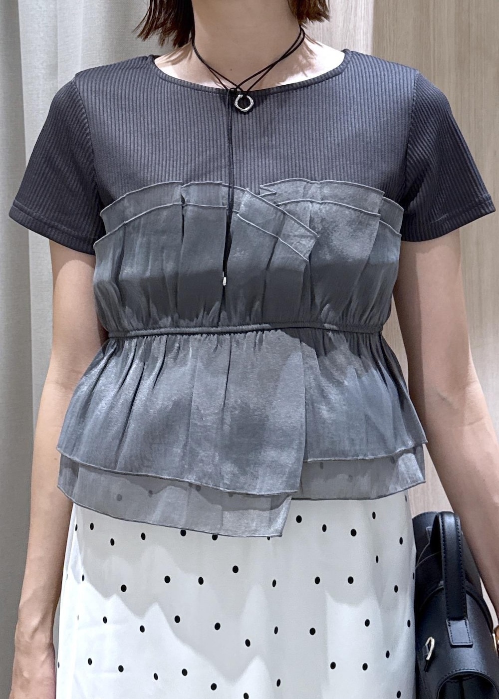 ブラック系のショルダーバッグ、ブラック系のTシャツ/カットソー、ブラック系のパンプスを着用したレディースの夏コーディネートの6枚目の写真
