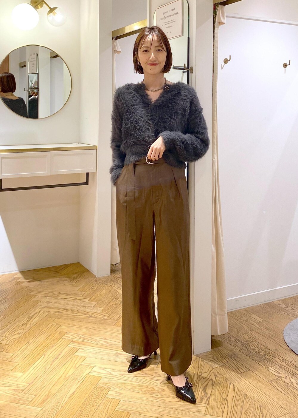 ブラック系のパンプス、グレー系のカーディガン/ボレロ、ブラウン系のピーコートを着用したレディースの冬コーディネートの7枚目の写真