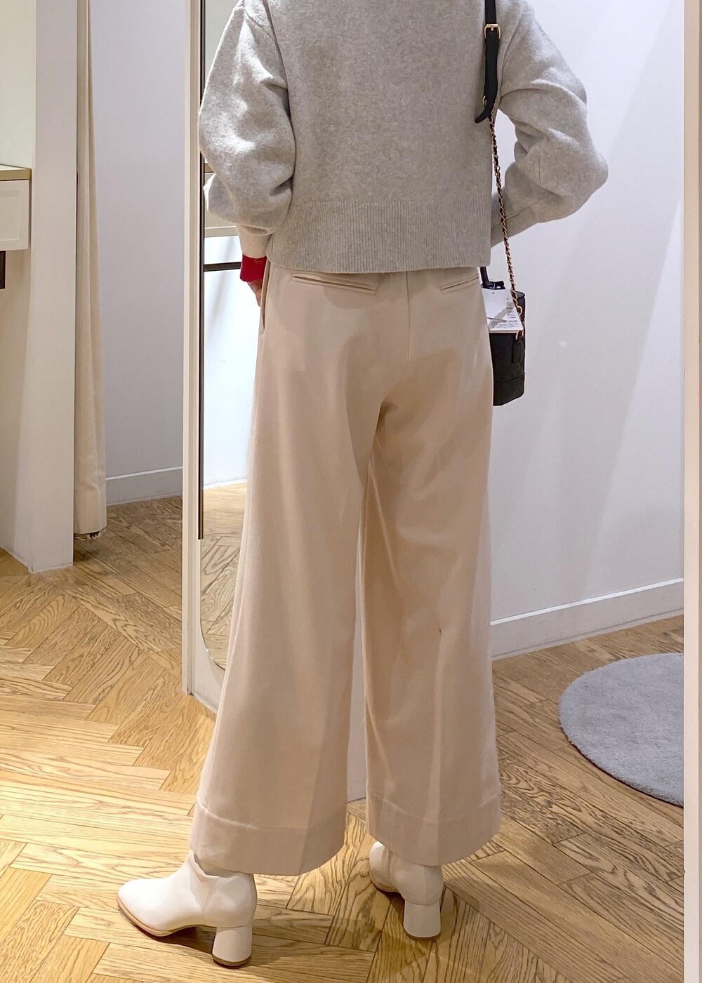 ホワイト系のブーツ、グレー系のカーディガン/ボレロ、レッド系のニット/セーターを着用したレディースの冬コーディネートの6枚目の写真