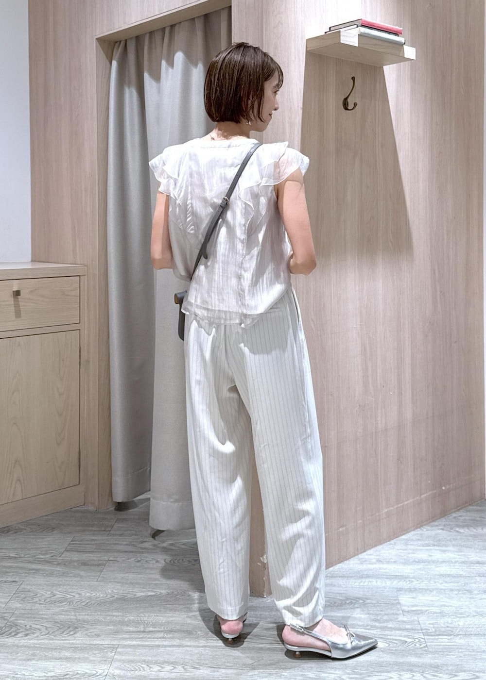 グレー系のショルダーバッグ、シルバー系のパンプス、ベージュ系のシャツ/ブラウスを着用したレディースの夏コーディネートの4枚目の写真