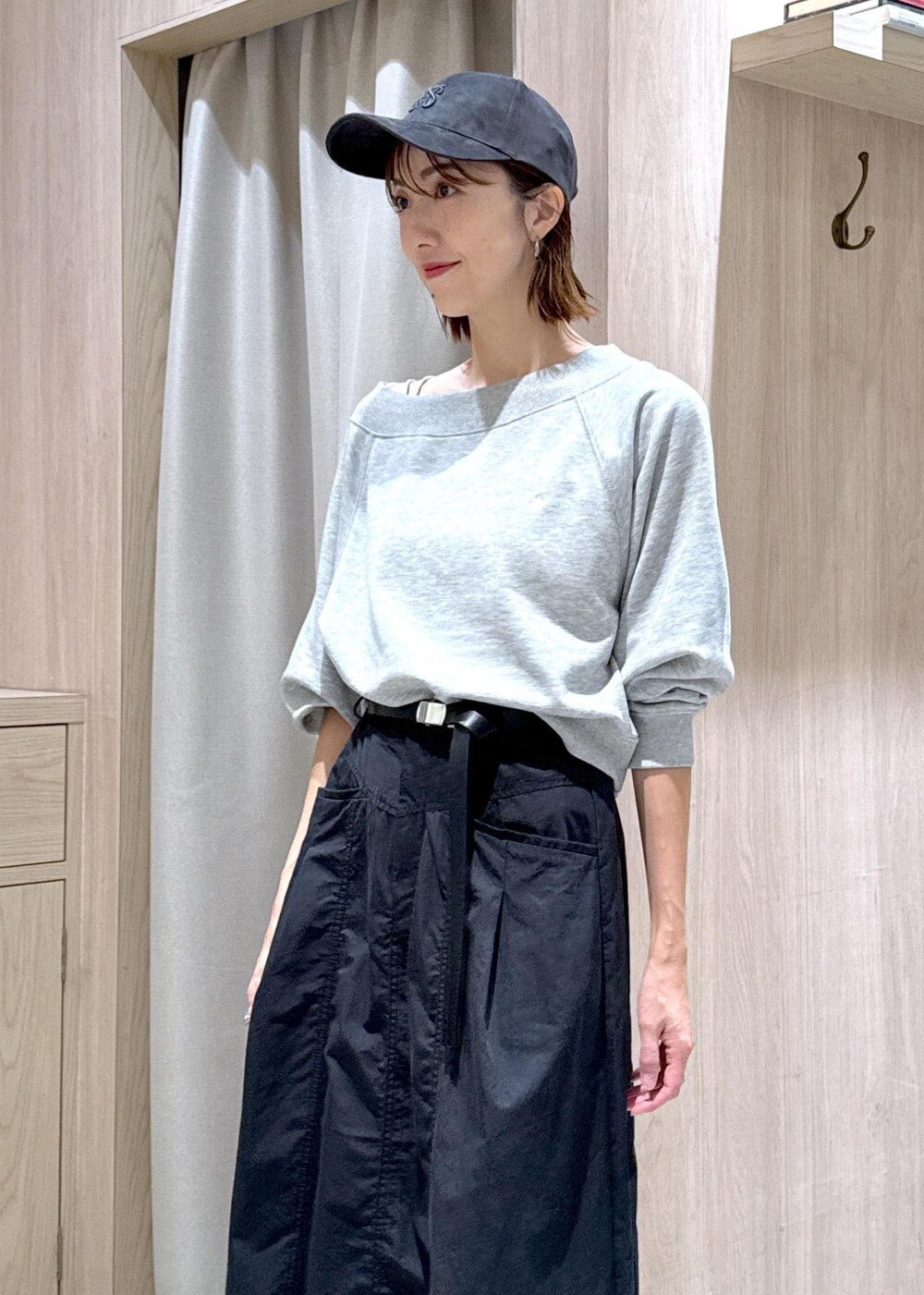 シルバー系のショルダーバッグ、ブラック系のスカート、ホワイト系のキャミソールを着用したレディースの秋コーディネートの6枚目の写真