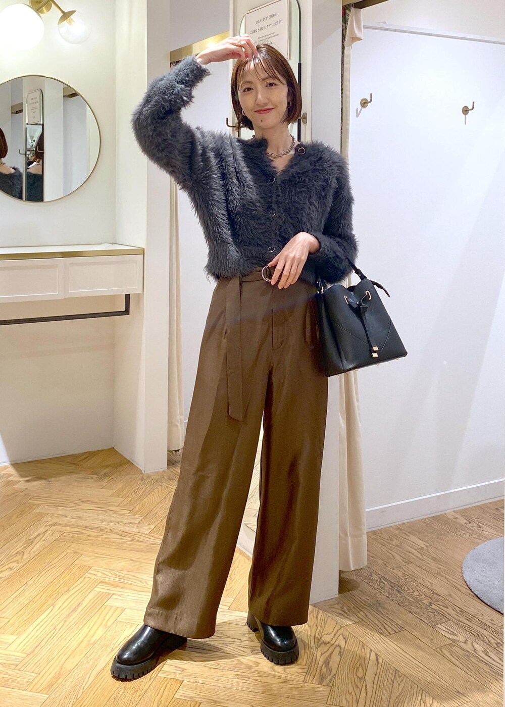 ブラック系のショルダーバッグ、ブラック系のブーツ、グレー系のカーディガン/ボレロを着用したレディースの冬コーディネートの4枚目の写真