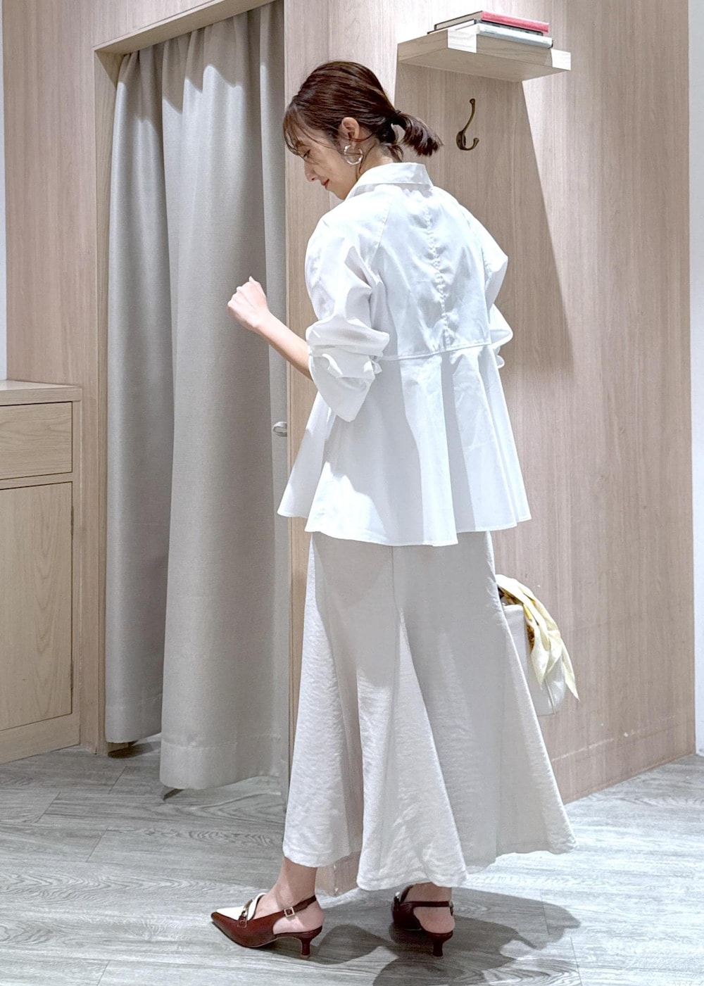 ホワイト系のシャツ/ブラウス、ホワイト系のショルダーバッグ、ブラウン系のパンプスを着用したレディースの春コーディネートの3枚目の写真