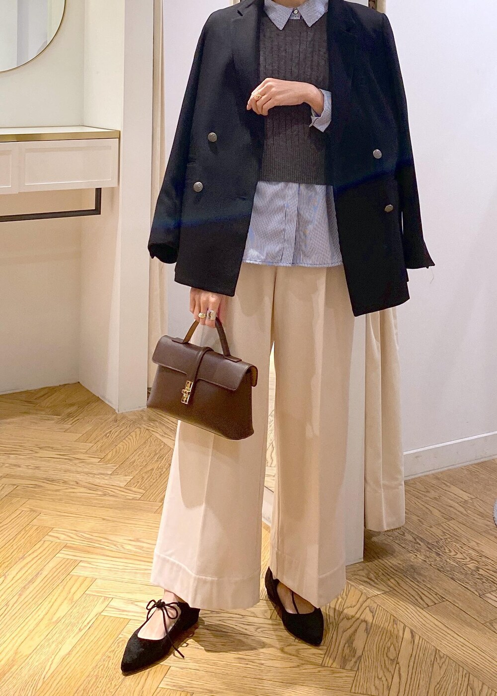 ブラウン系のショルダーバッグ、ブラック系のテーラードジャケット、ブルー系のシャツ/ブラウスを着用したレディースの冬コーディネートの4枚目の写真