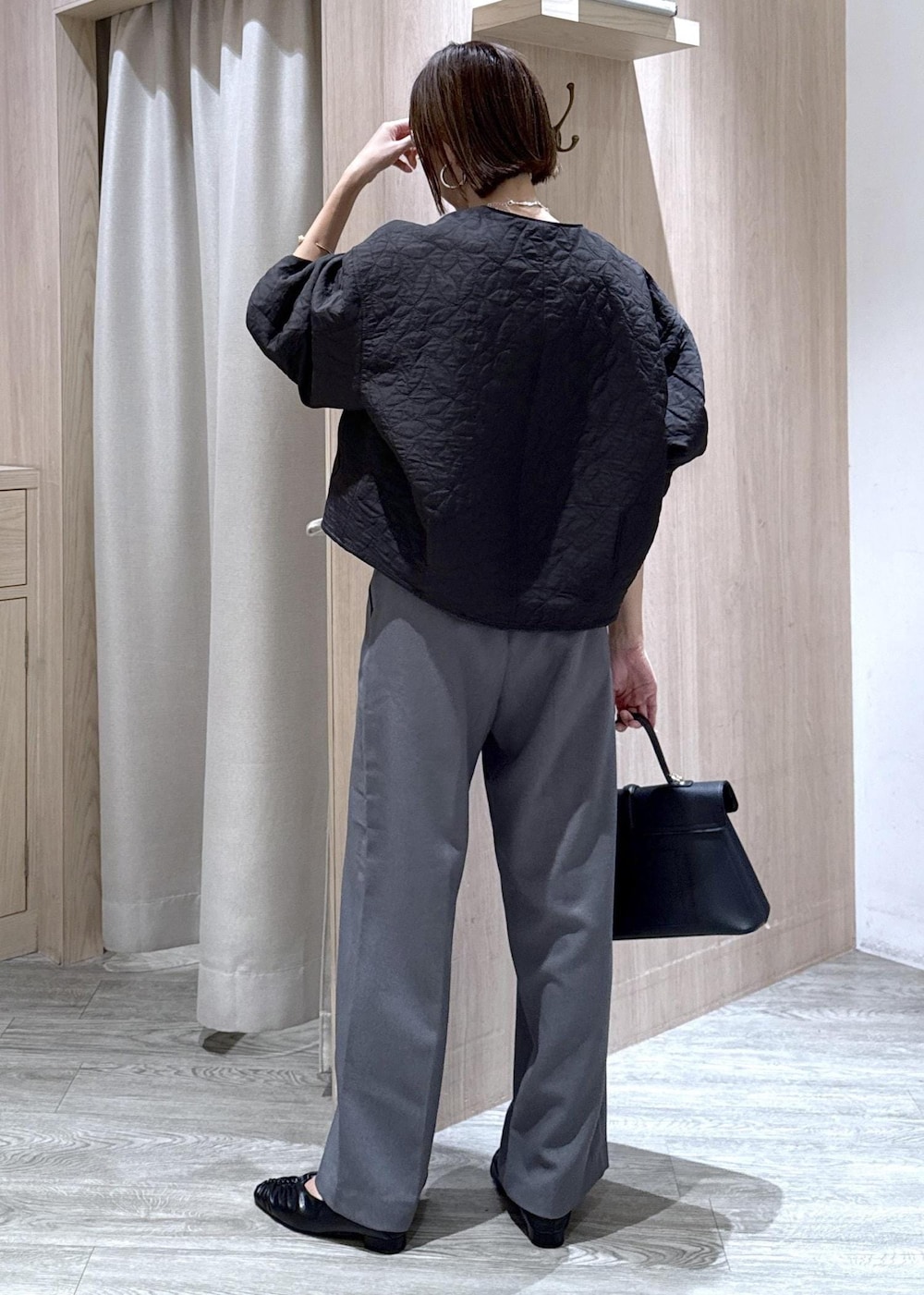 ブラック系のハンドバッグ、グレー系のスラックス、ホワイト系のシャツ/ブラウスを着用したレディースの秋コーディネートの4枚目の写真