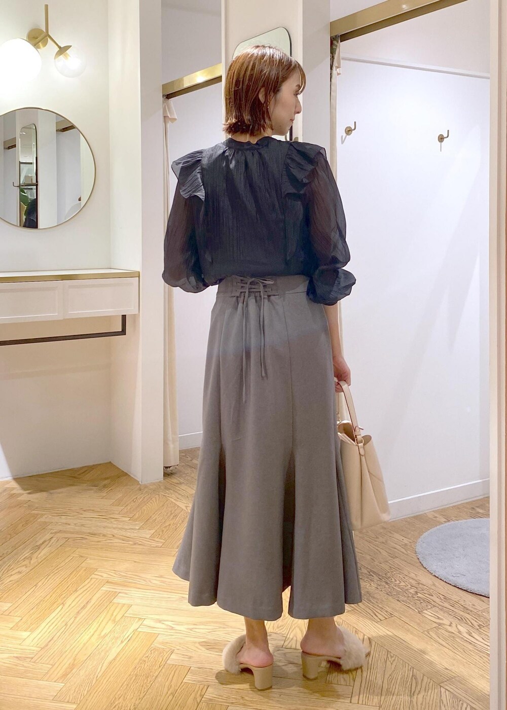 ブラック系のキャミソール、ベージュ系のドレスシューズ、ベージュ系のショルダーバッグを着用したレディースの秋コーディネートの3枚目の写真