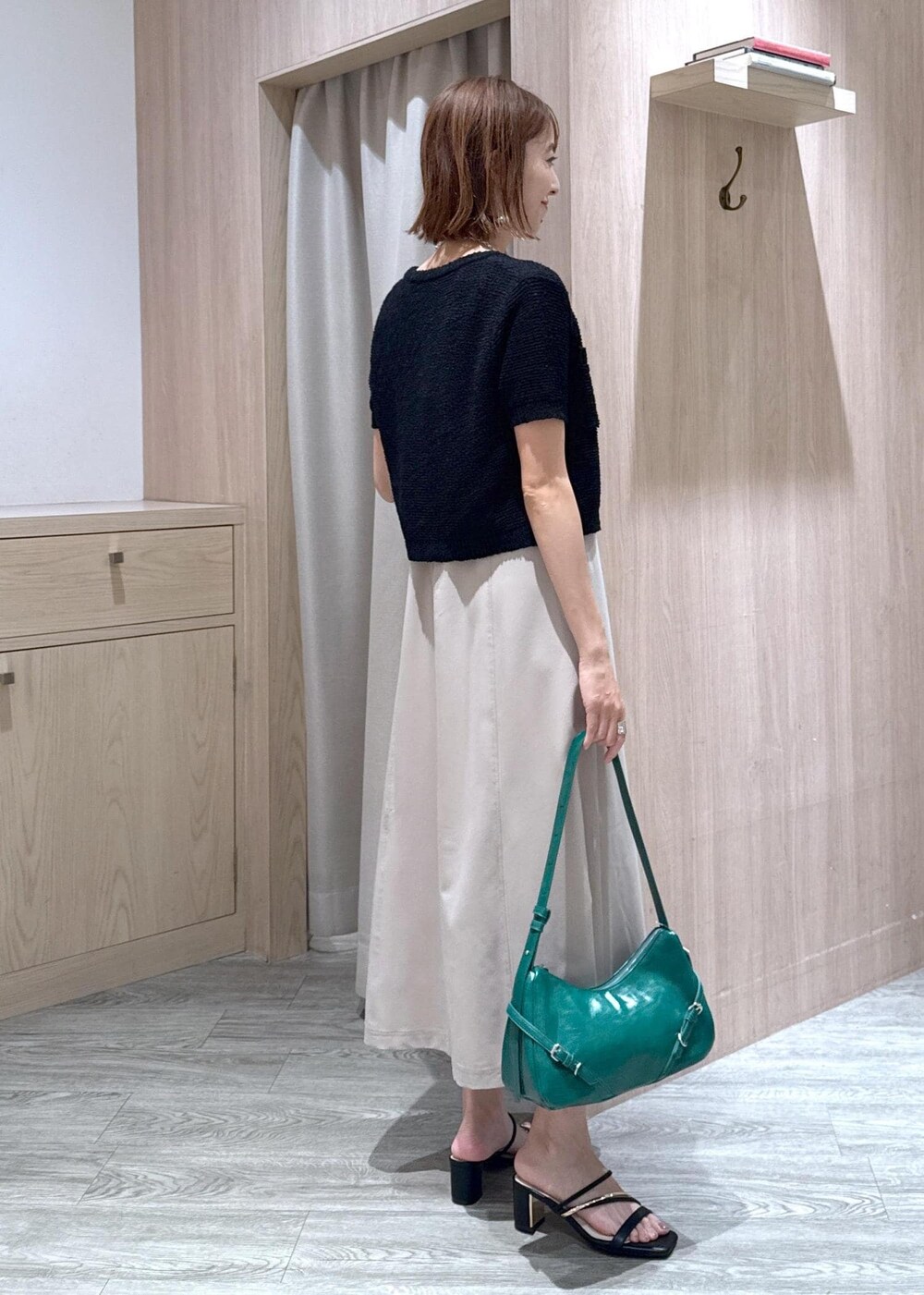 ホワイト系のキャミソール、ブラック系のサンダル、ブラック系のカーディガン/ボレロを着用したレディースの夏コーディネートの2枚目の写真