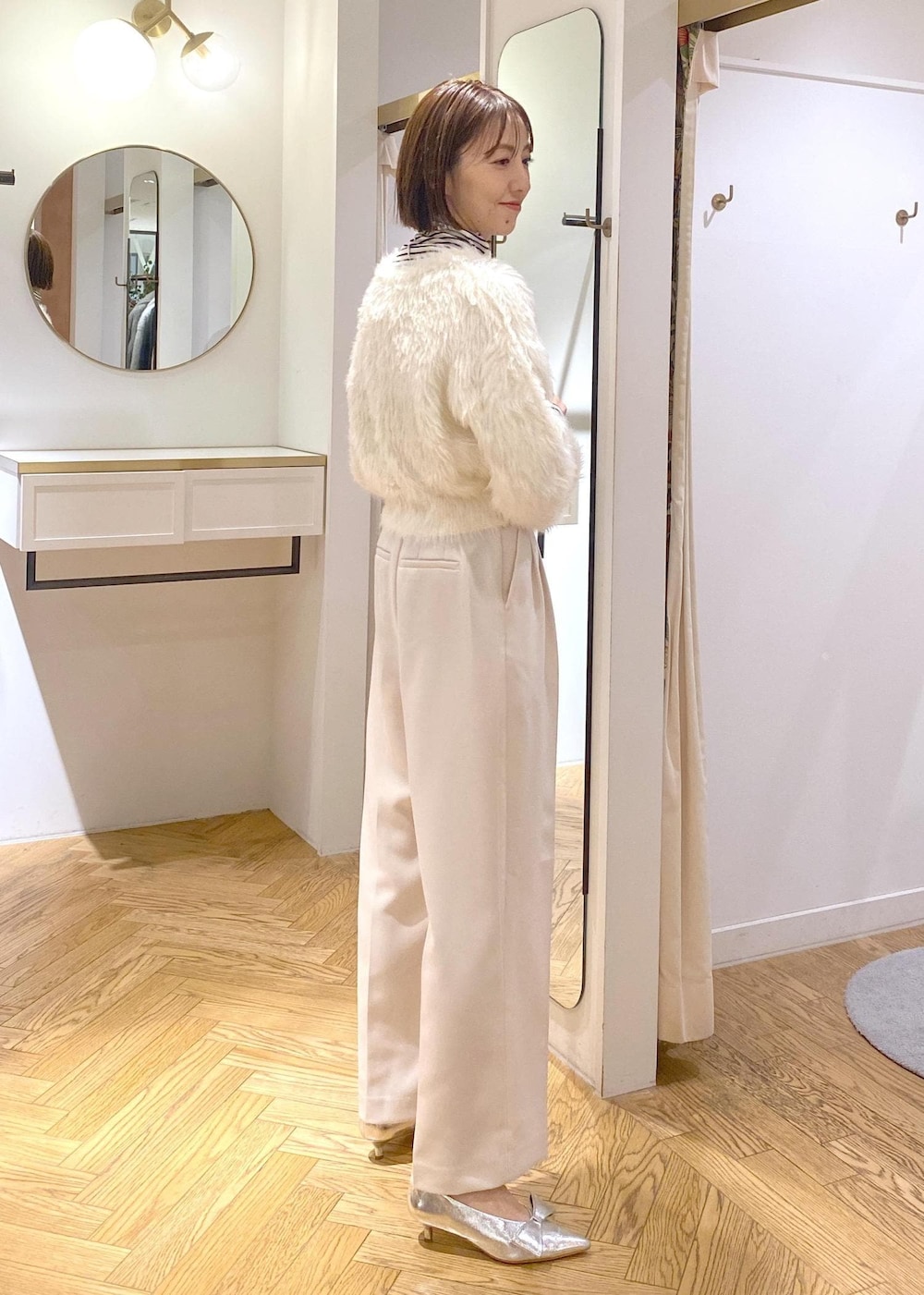 シルバー系のパンプス、ホワイト系のカーディガン/ボレロ、ホワイト系のTシャツ/カットソーを着用したレディースの冬コーディネートの2枚目の写真