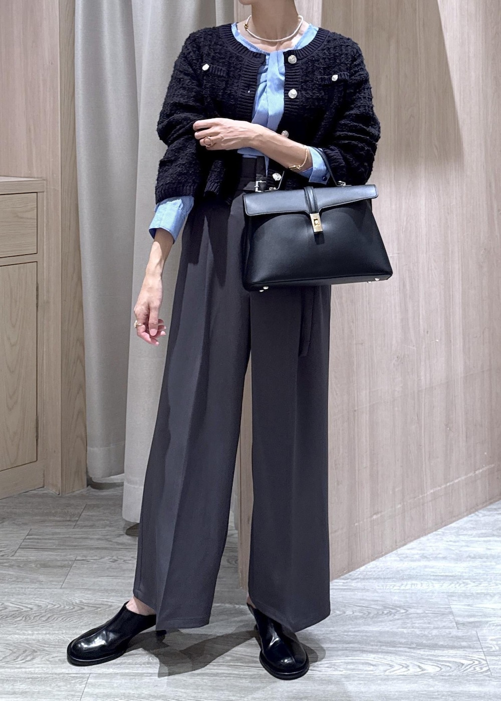 ブラック系のハンドバッグ、ブルー系のカーディガン/ボレロ、グレー系のその他パンツを着用したレディースの秋コーディネートの7枚目の写真
