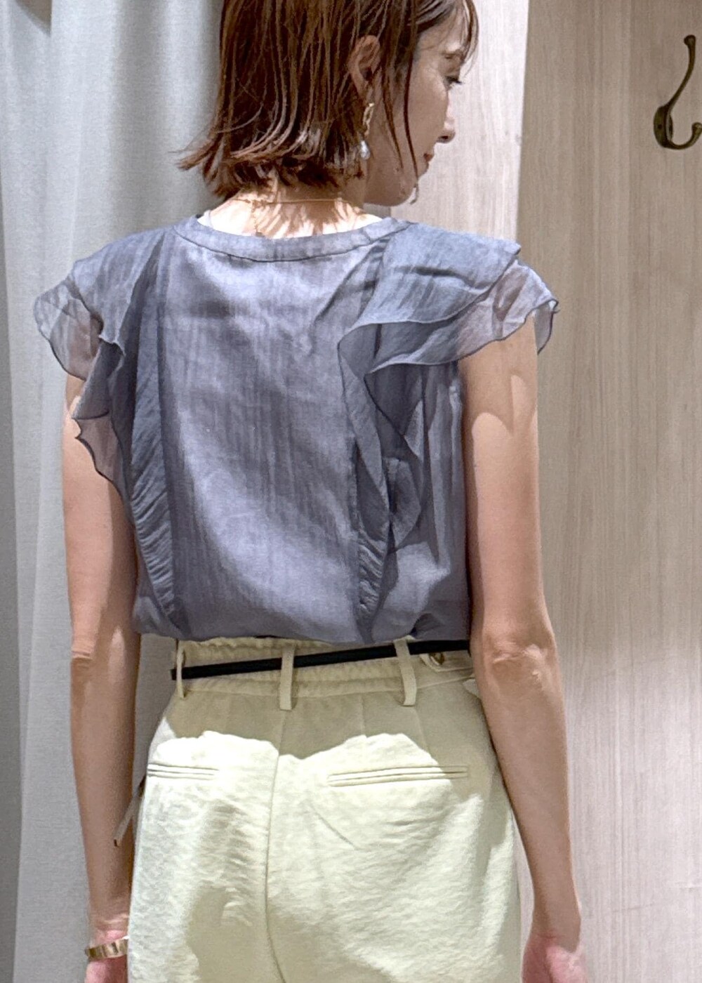 ホワイト系のショルダーバッグ、ホワイト系のサンダル、イエロー系のスラックスを着用したレディースの夏コーディネートの9枚目の写真