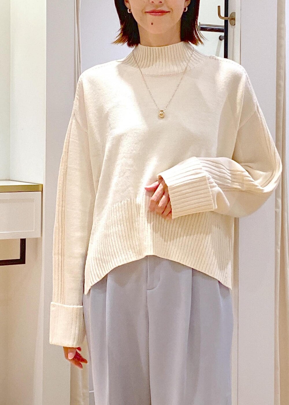 シルバー系のパンプス、ブラック系のショルダーバッグ、ブルー系のスラックスを着用したレディースの秋コーディネートの9枚目の写真