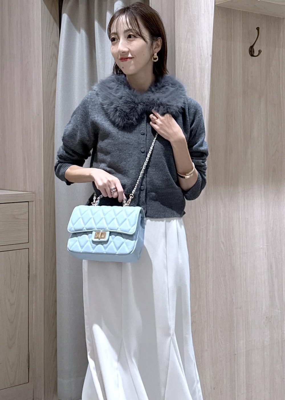 シルバー系のパンプス、ホワイト系のキャミソール、ホワイト系のスカートを着用したレディースの冬コーディネートの7枚目の写真