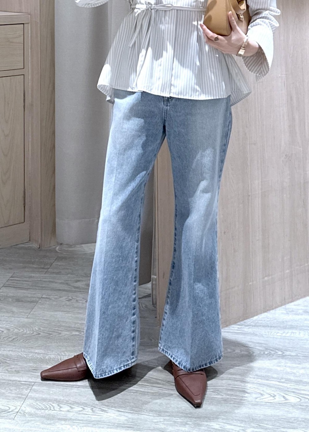 ブルー系のデニムパンツ、イエロー系のショルダーバッグ、ベージュ系のシャツ/ブラウスを着用したレディースの春コーディネートの4枚目の写真