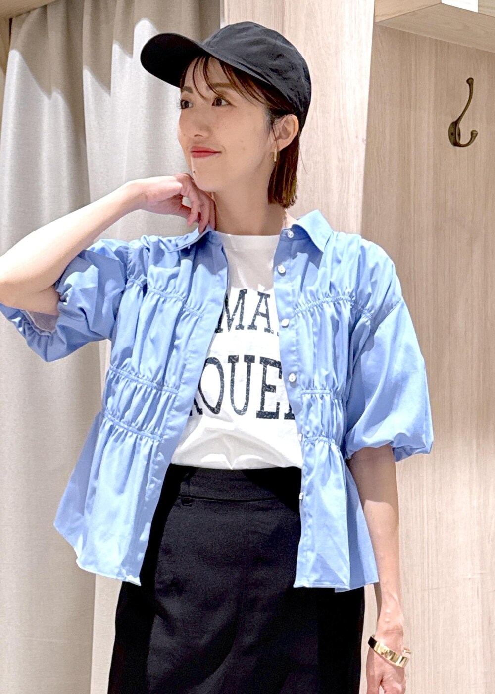 ブラック系のショルダーバッグ、ブラック系のスカート、ホワイト系のTシャツ/カットソーを着用したレディースの春コーディネートの8枚目の写真