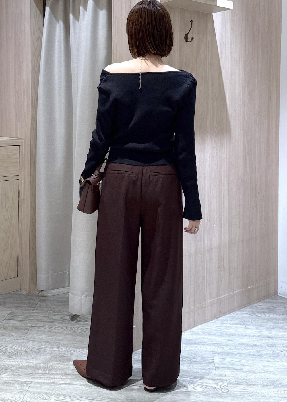 ブラウン系のその他パンツ、ブラウン系のショルダーバッグ、ブラック系のニット/セーターを着用したレディースの秋コーディネートの2枚目の写真