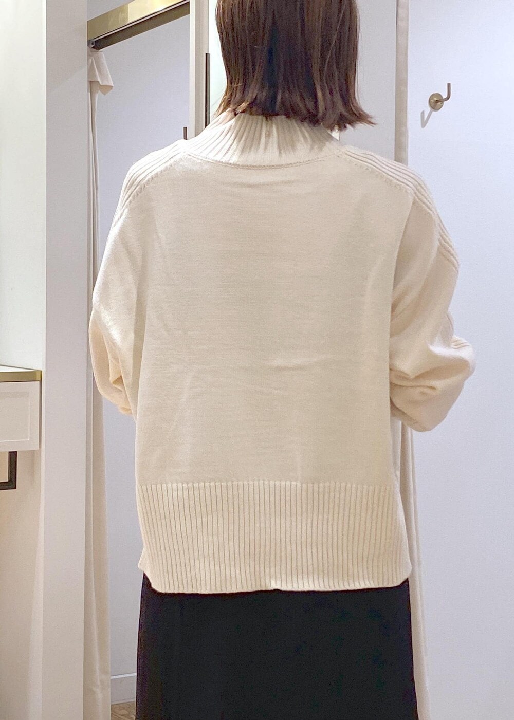 ブラック系のスカート、ホワイト系のニット/セーター、グレー系のショルダーバッグを着用したレディースの秋コーディネートの8枚目の写真