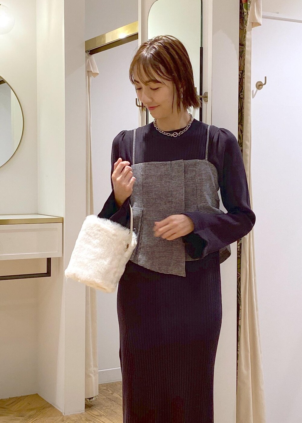 ブラック系のサンダル、ブラック系のワンピース、ホワイト系のショルダーバッグを着用したレディースの秋コーディネートの7枚目の写真