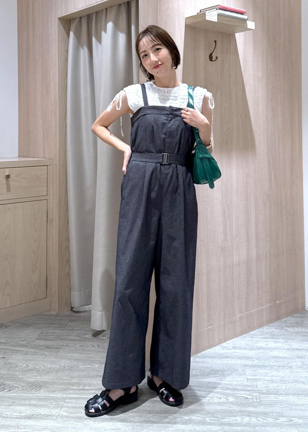 ホワイト系のキャミソール、ホワイト系のシャツ/ブラウス、グリーン系のハンドバッグを着用したレディースの夏コーディネートの2枚目の写真